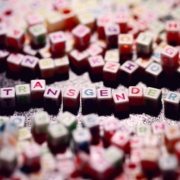 Beads with multicoloured letters on, spelling out the word transgender